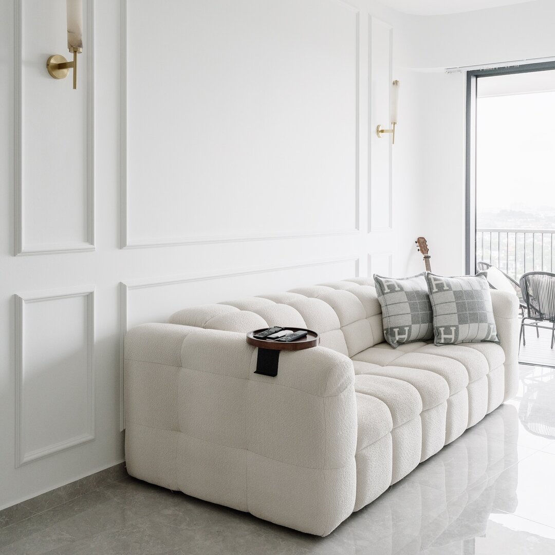 A white quilted Son&Bear sofa against classic wainscoting in a customer's living room